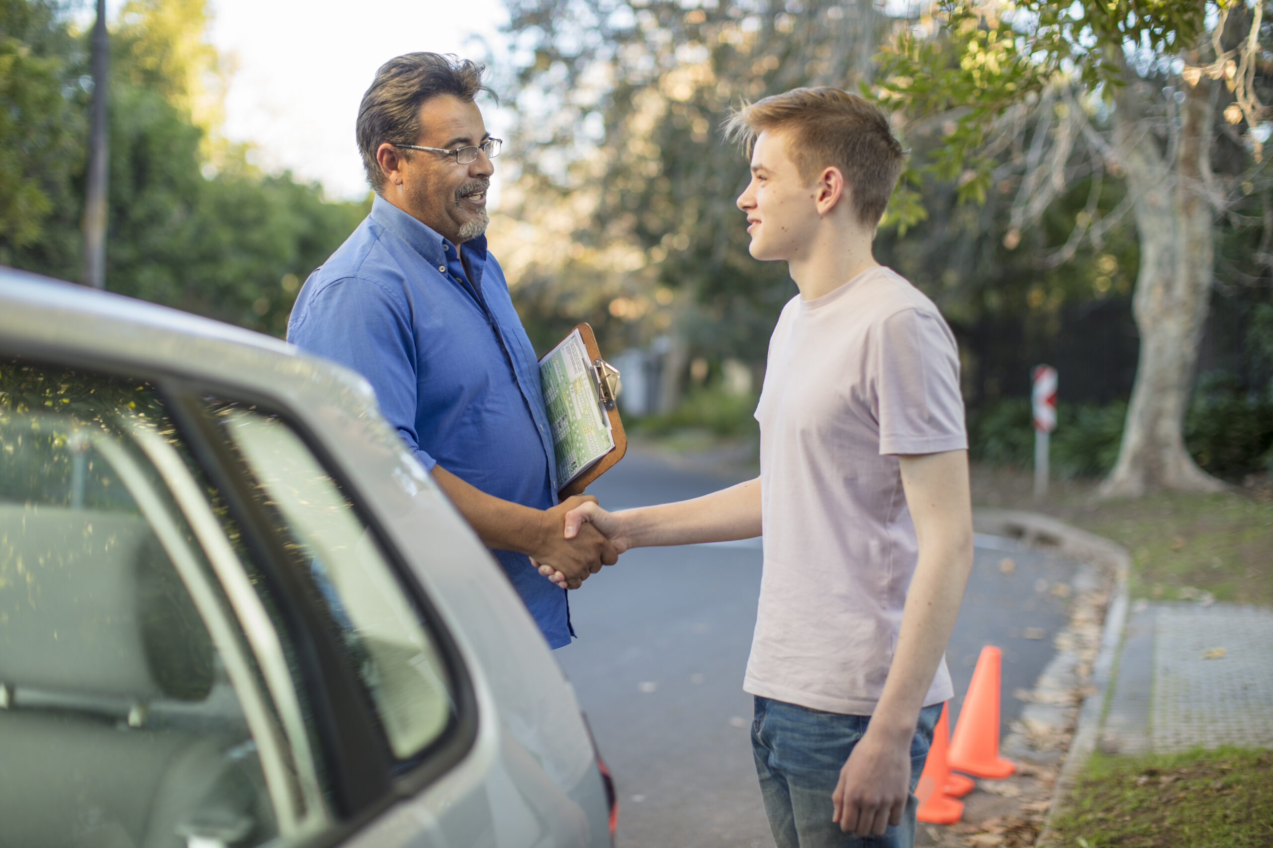 learner driver and instructor shaking hands at car 2023 11 27 05 22 20 utc scaled